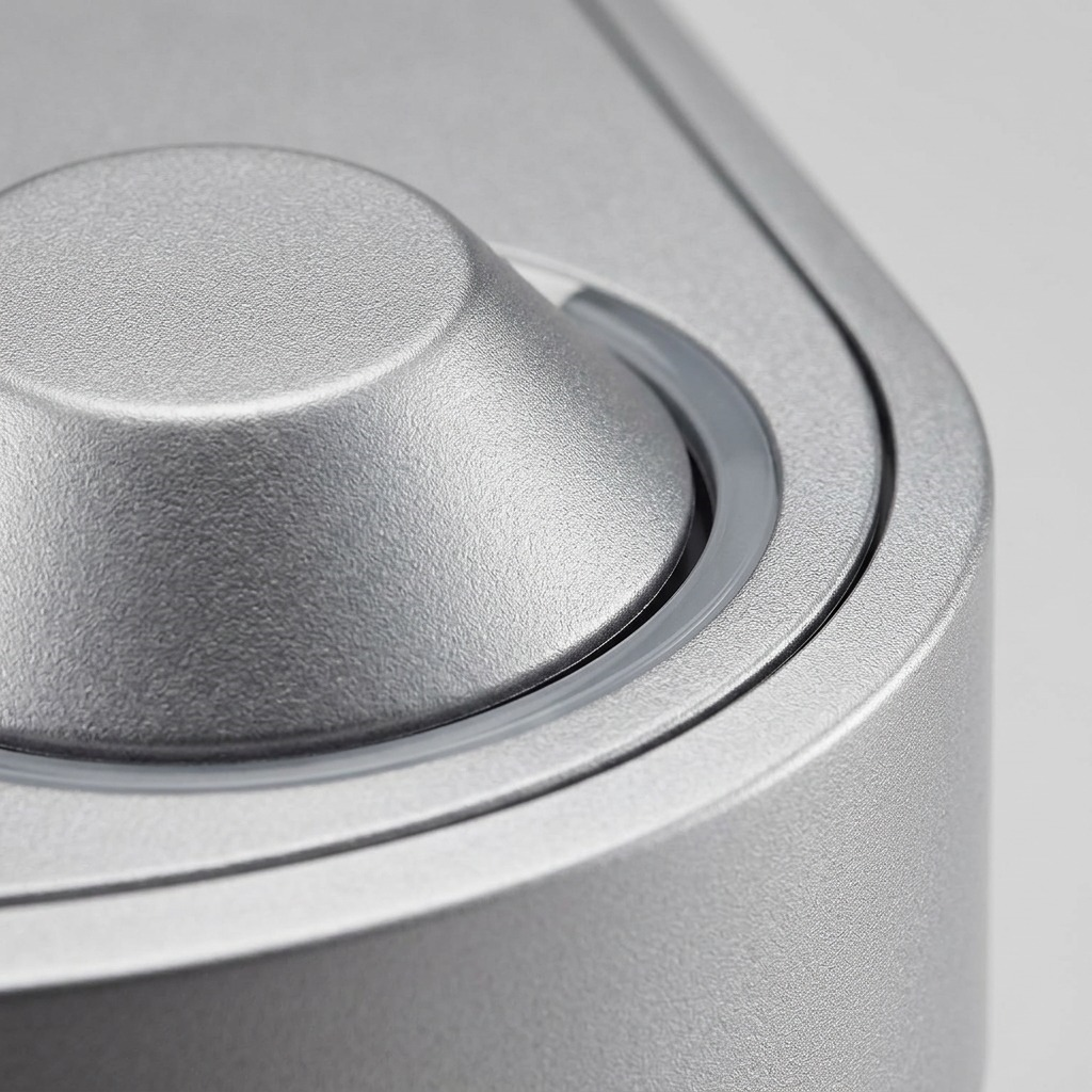A macro photo focuses on the texture of the metallic finish and precision of the single button and indicator.